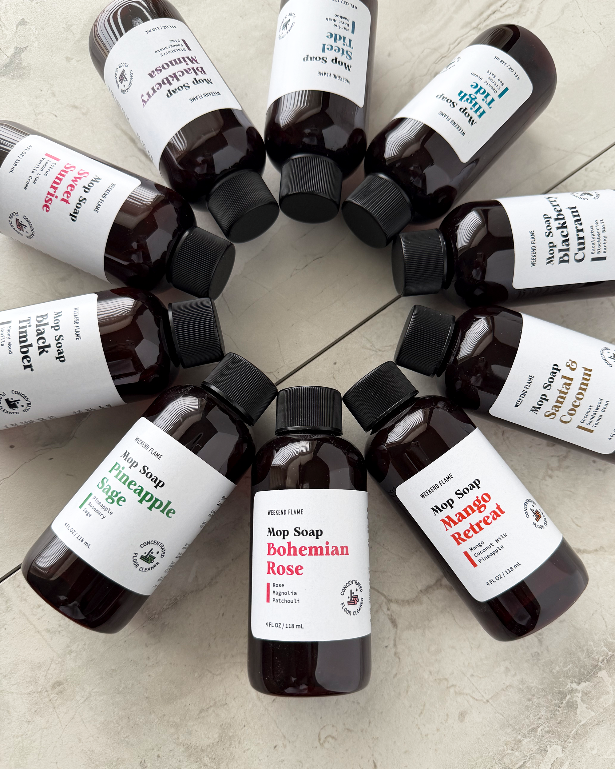 Various bottles of mop soap arranged in a circle on a light surface