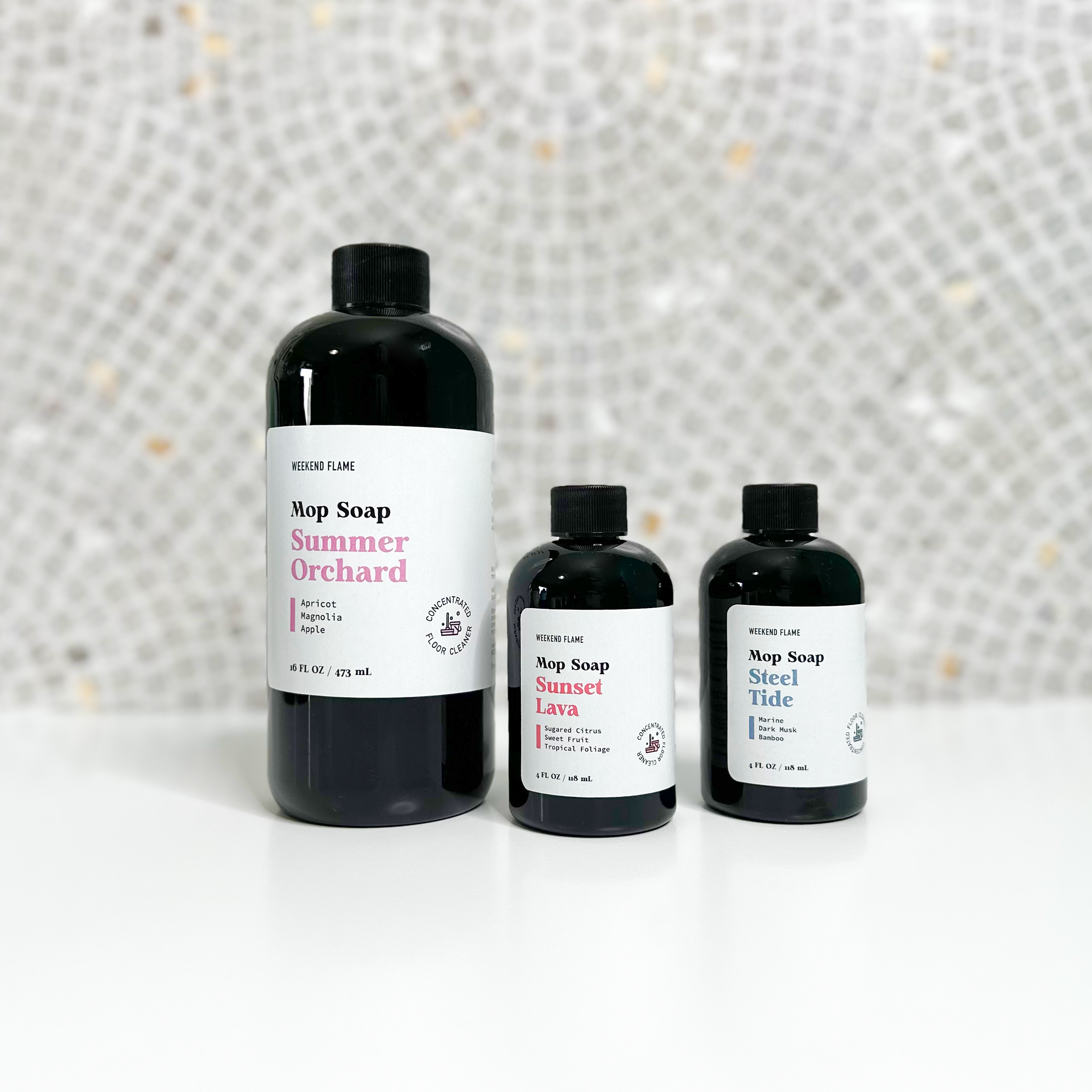 Trio of luxury mop soap concentrates in sleek packaging. High performance mop soap in full-size and mini bottles