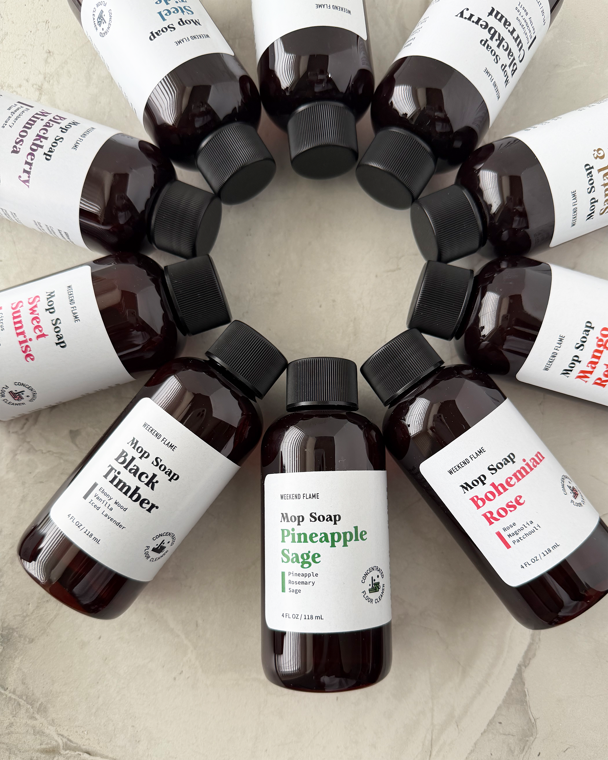 Assorted scents mop soap bottles arranged in a circular pattern on a light background.