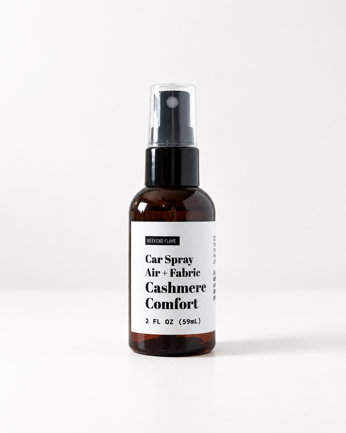 An amber car spray bottle with a black pump and a white label reading 'Car Spray Air + Fabric Cashmere Comfort' on a clean white background.