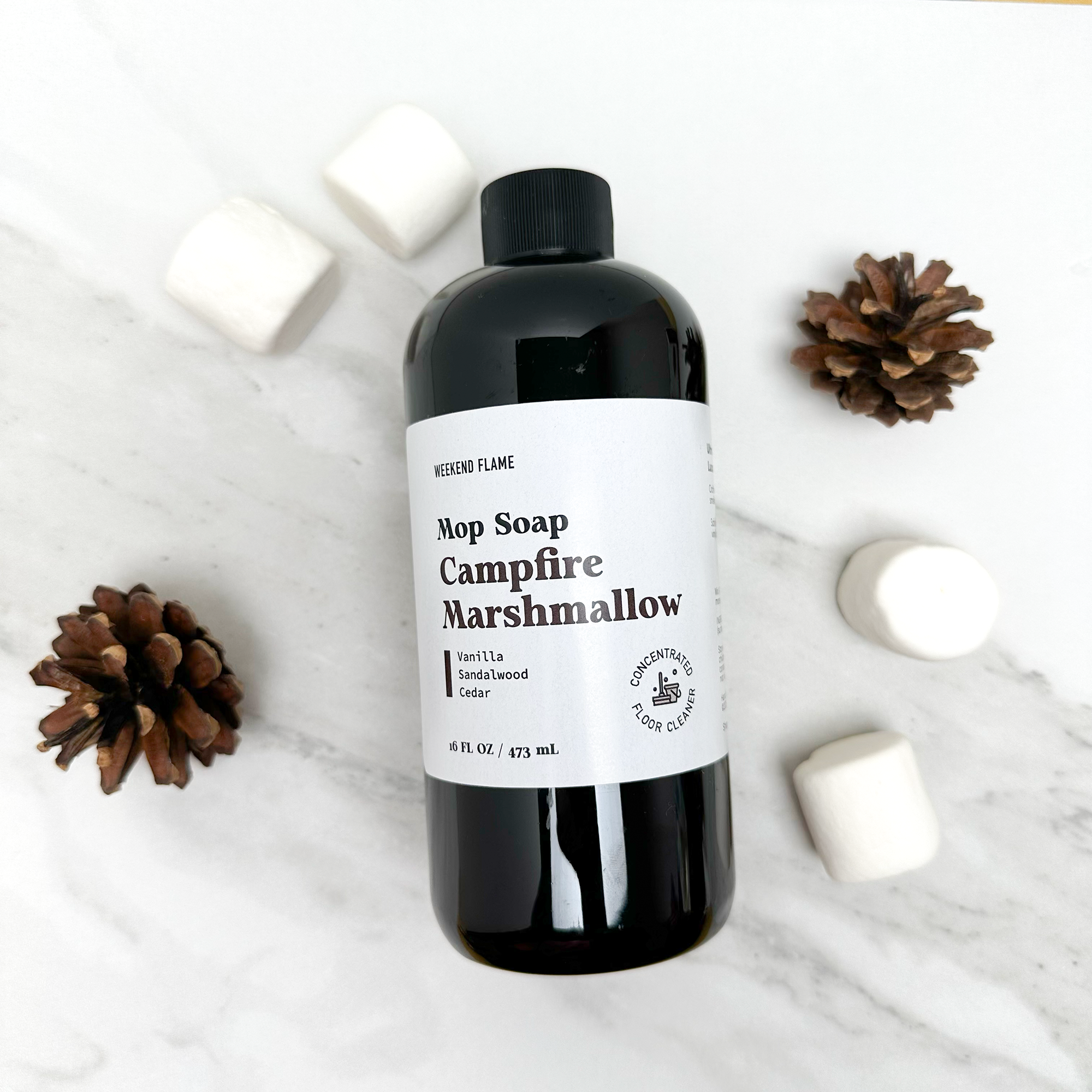 Bottle of 'Campfire Marshmallow' fall scented mop soap with decorative elements on a white background