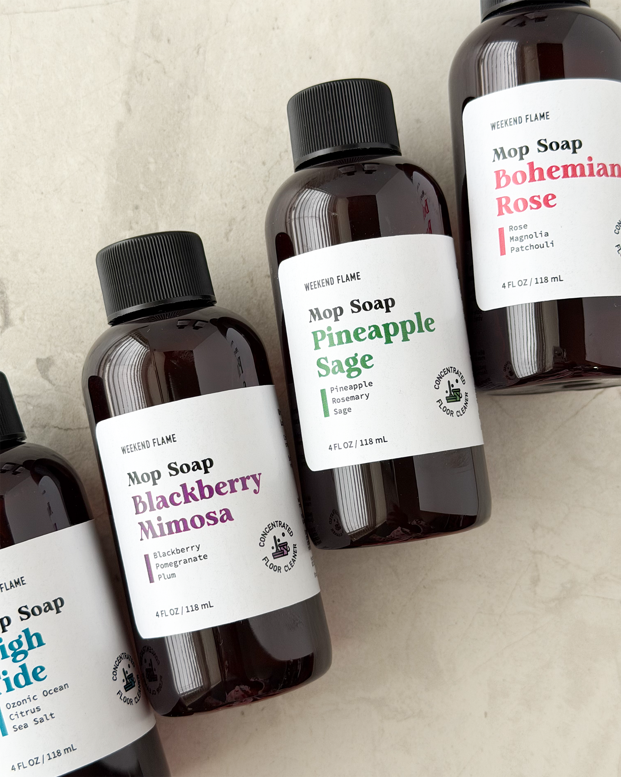 Bottles of Mop Soap with labels on a textured surface