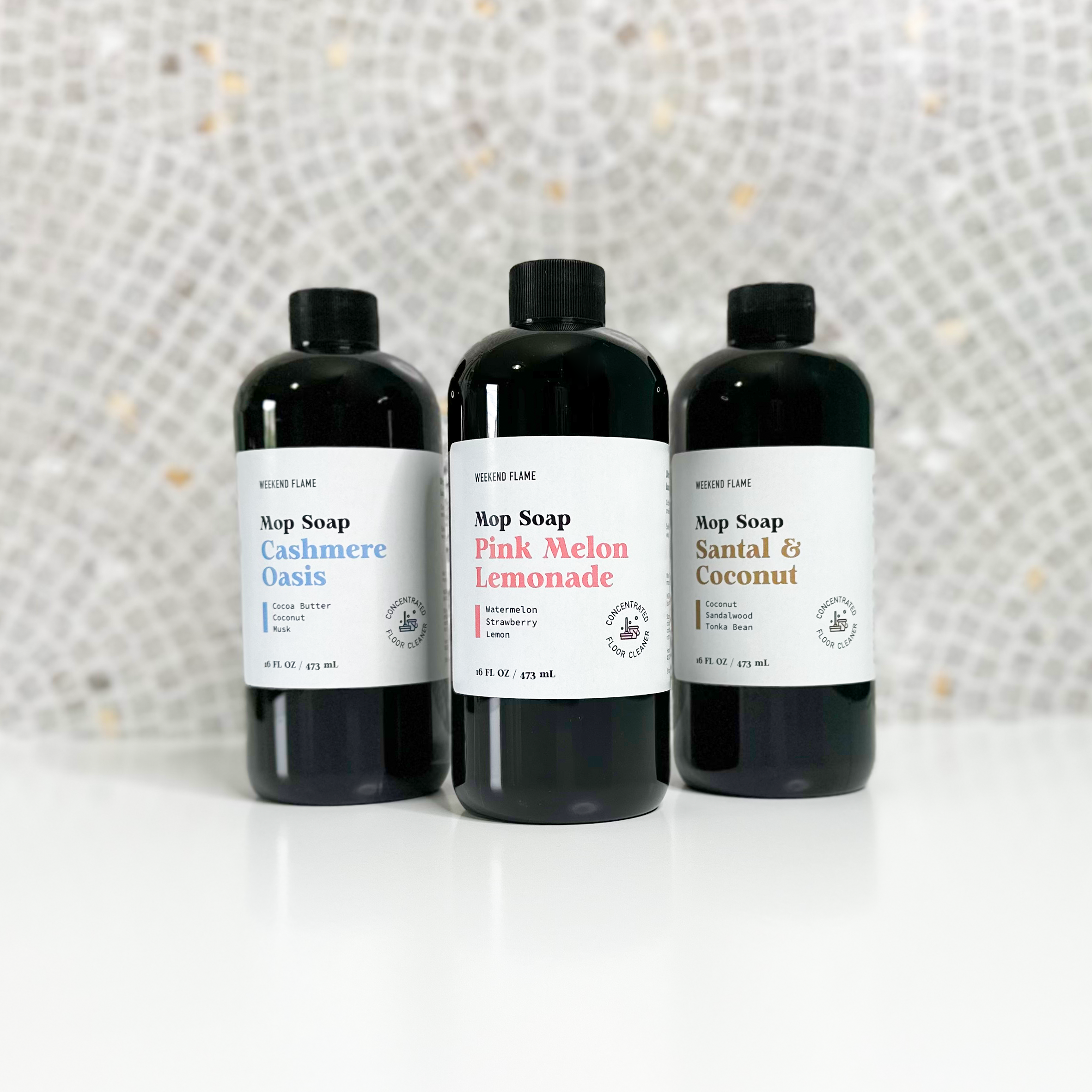 Three bottles of scented mop soap floor cleaner in assorted fragrances