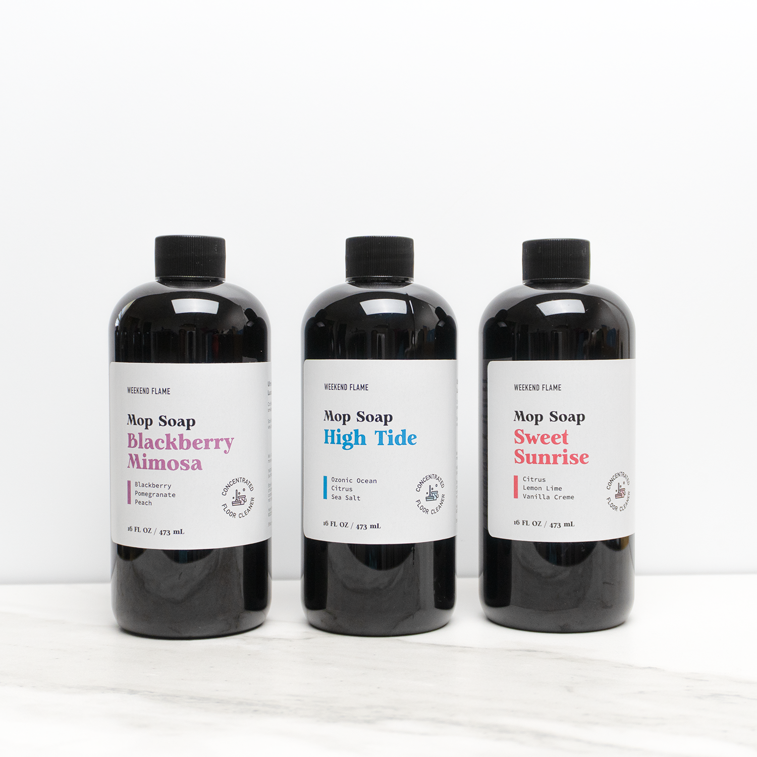 Three bottles of Mop Soap with different scents on a white background